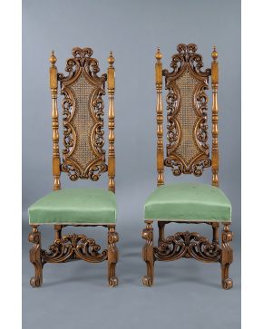 377-Pareja de sillas españolas en madera tallada con respaldo alto profusamente tallado y centro en rejilla. Asientos en tela verde.