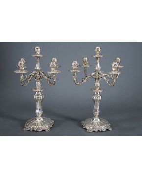818-Gran pareja de candelabros de cinco luces convertibles en candeleros en plata española punzonada con decoración relevada de tornapuntas y motivos vege