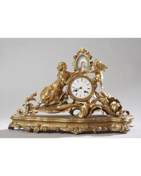 301-Reloj de sobremesa francés de bronce dorado. fines S. XIX. Sobre una peana de madera tallada y dorada. 