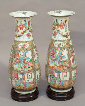 569-Pareja de jarrones en porcelana china cantonesa. S.XIX. Uno restaurado. Sobre peanas de madera.