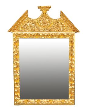 731-Marco con espejo de estilo barroco en madera tallada y dorada. con copete en forma de frontón partido.