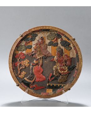 994-Plato en cerámica oriental. S. XIX. Decoración de personajes representando escena teatro japonés. relieve lacado y dorado. Pequeño desperfecto.