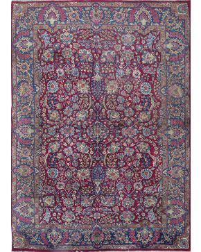 740-Alfombra persa en lana con decoración de flores sobre campo granate. Algún desperfecto.
