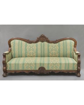482-Elegante sofá alfonsino en madera de caoba con decoración tallada de hojas y gran copete en forma de venera. Patas de lenteja y tapicería adamasquinad