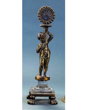 1497-Antiguo y delicado reloj de sol en bronce dorado con figura de niño portando la esfera sobre cuerno de la abundancia. Sobre peana en cristal tallado y