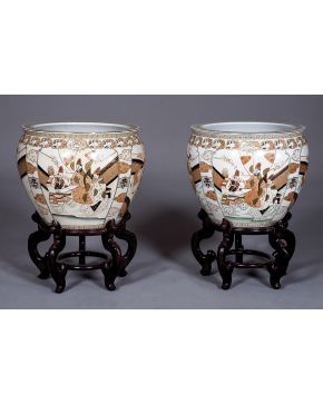 993-Pareja de decorativas peceras orientales en porcelana esmaltada sobre fondo blanco con representación de personajes. Sobre peanas de madera.