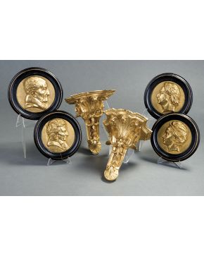 370-Pareja de decorativos tondos en bronce dorado con representación en relieve de bustos masculinos. Enmacados. S. XIX. Con inscripciones grabadas.