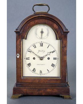 374-Antiguo reloj de sobremesa inglés en madera de caoba. con marcas en la esfera Yardley. London. Aplicaciones de bronce dorado.
