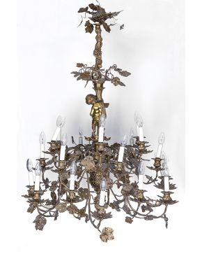 478-Gran lámpara de techo de 24 luces en bronce con originales brazos en forma de hoja de parra y uvas. S. XIX. Con fuste con ángel portando un cuerno de 