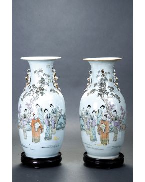 813-Pareja de jarrones en  porcelana china con decoración de personajes en paisaje y epigrafía. Sobre peanas de madera. 