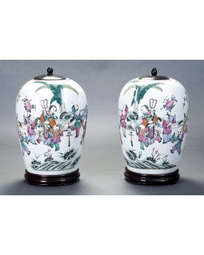812-Pareja de tibores chinos en porcelana china esmaltada con tapas y soporte en madera. Decoración de personajes en paisajes. 