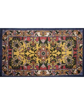 829-Alfombra en lana de nudo español de la Real Fabrica de Tapices con decoración vegetal y de tornapuntas sobre campo rojo y amarillo con cenefa en beige
