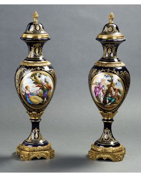 602-Pareja de jarrones estilo Sevres en porcelana esmaltada azul cobalto con escenas pastoriles en la panza y detalles en dorado. Montura y aplicaciones e