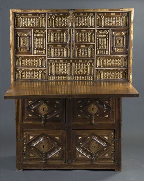 675-Bargueño salmantino en madera de nogal tallada y dorada con aplicaciones de hueso S. XVII. sobre mueble taquillón.