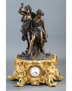 608-Reloj de sobremesa francés s. XIX. base en bronce dorado con gran movimiento de palmetas y flores. Importante escultura de Otoño de dos ninfas entre