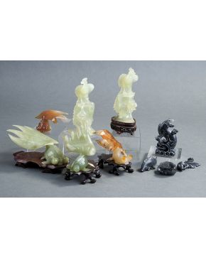 991-Lote formado por seis figuras en jade: pareja de pavos reales y 4 peces. Algunos en sus peanas de madera. Pequeñas faltas.