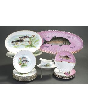 596-Lote de dos vajillas formado por juego en loza esmaltada formado por: 1 fuente oval y 6 platos llanos con decoración de peces sobre fondo rosa; y jueg