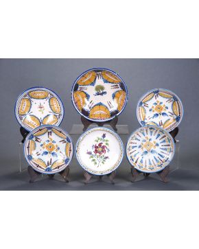 496-Lote de cinco platos y fuente de cerámica de Manises en diversos colores. con decoración de flores y cuatro de ellos de cortinillas. Dos de ellos re