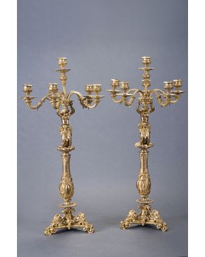587-Pareja de candelabros de seis luces en bronce dorado. S. XIX. con fuste a modo de querubin tenante sobre columna acanalada decorada con espejos. Apoya