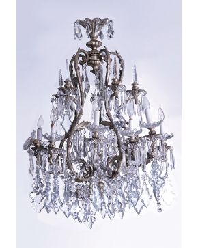 462-Gran lámpara de techo de diez luces en cristal y metal plateado. Decoración de pandelocas. prismas colgantes y pináculos en dos alturas.  Algún desper