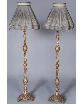 1027-Pareja de lámparas de pie en forma abalaustrada en metal dorado con profusa decoración cincelada.