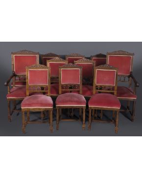 752-Sillería compuesta por 12 sillas y 2 sillones en madera de nogal. Tapicería en terciopelo granate. Copete tallado de elementos vegetales y rocallas y 