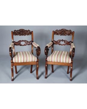 428-Pareja de sillas. S. XIX. en madera de caoba talladas con decoración de elementos vegetales y rocallas y brazos a modo de volutas. Tapicería de rayas.