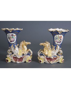509-Pareja de floreros isabelinos en porcelana esmaltada con forma de cuerno de la abundancia y caballos marinos. Consolaciones.