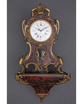 593-Reloj de cartel con ménsula Napoleón III. S. XIX. en madera ebonizada con marquetería  Boullé en latón y carey. Aplicaciones de bronce dorado. Esfera 