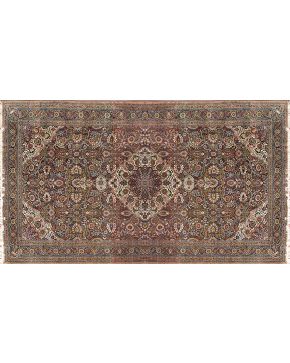 606-Gran alfombra persa en lana con campo granate y medallón central. Profusa decoración de motivos florales y vegetales. Colore complementarios: verde. a