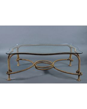1122-Mesa de centro con patas a modo de cordón en metal dorado y tapa de cristal ondulado. 