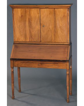 464-Mueble escritorio. s. XIX. en madera tallada con cuerpo superior con doble puerta y estantes interiores. tapa abatible y cajón en cintura. Con llave.
