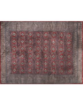 746-Alfombra persa en lana con decoración geométrica sobre campo granate. 