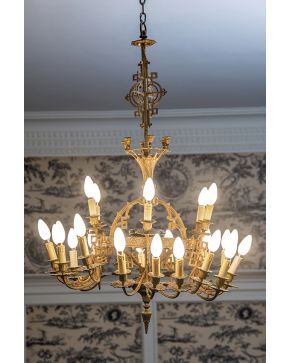 684-Lámpara de techo estilo neogótico de 24 luces en bronce dorado con brazos formados por motivos recortados.