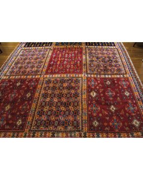 576-Gran alfombra oriental en lana con campo central compartimentado con motivos geométricos en tonos ocres. granates. azules y naranjas. 