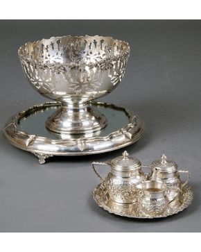758-Centro de mesa o frutero en plata egipcia punzonada. Borde calado con decoración floral y vegetal. Sobre bandeja de plata y espejo.