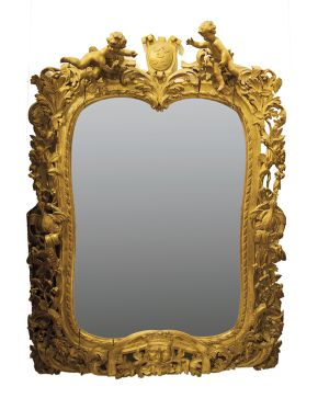 916-Gran espejo con marco neobarroco en madera tallada y dorada con decoración calada con motivos vegetales. florales y de aves. Mascarón inferior y remat