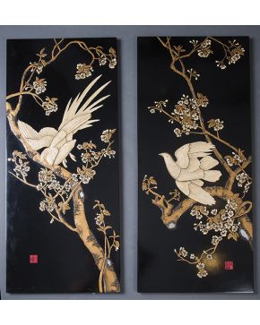 439-Pareja de paneles estilo oriental en madera lacada y policromada con representación en relieve de ramas. flores y aves. 