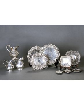 733-Lote formado por tres jarras para agua en plata española punzonada. dos de ellas con decoración helicolidal. La más grande con decoración cincelada de