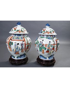 1031-Pareja de tibores con tapa en porcelana china Wucai. Decoración de escenas de cortesanas y niños jugando en la tapa.