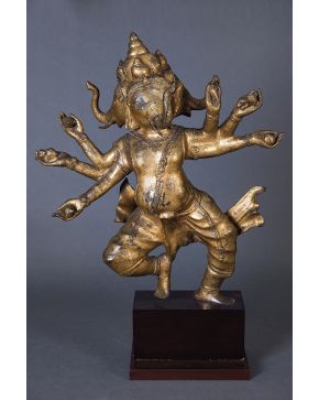1057-Dios Ganesha hindú en metal dorado. Figura danzante representando al dios con tres cabezas de elefante y seis brazos.