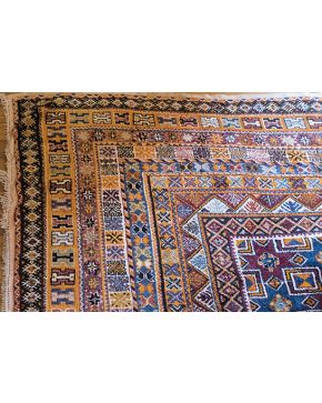 1064-Alfombra oriental en lana con decoración geométrica sobre campo naranja. Colores complementarios: azul y marrón.