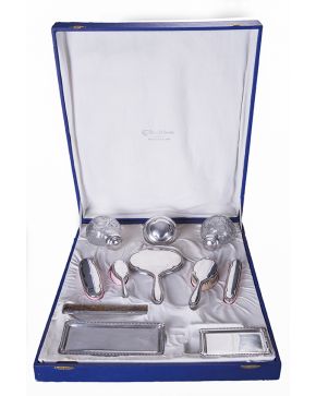 712-Juego de tocador en plata española punzonada compuesto por: tres recipientes con tapa en plata y cristal moldeado y tallado a rueda. 4 cepillos. 1 pei