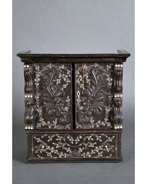 438-Pequeño cabinet de estilo oriental en madera tallada con aplicaciones de hueso y decoración floral. Parte superior con doble puerta e interior compart