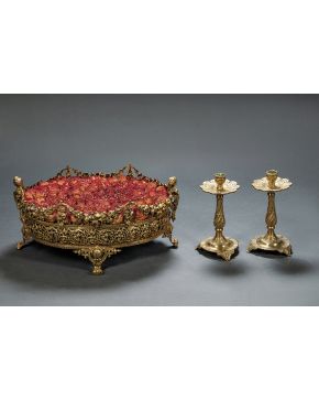 969-Centro de mesa en metal dorado y calado. Con decoración de guirnaldas. roleos. elementos vegetales y asas en forma de estípite y patas de voluta.