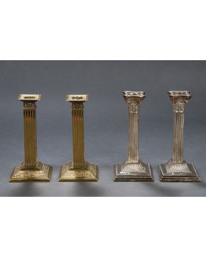 832-Pareja de candeleros en bronce dorado con fuste en forma de columna acanalada y base con relieve de hojas.