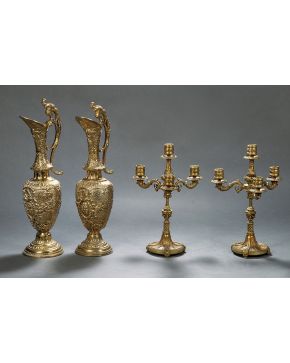 965-Pareja de jarras de bronce dorado con asa lateral. cuerpo con decoración cincelada en relieve de flores y guirnaldas y boca con cabezas.