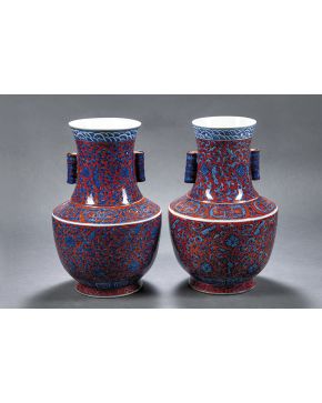 916-Pareja de jarrones en porcelana china decorados con motivos vegetales en azul cobalto sobre fondo granate. Con marcas en la base.