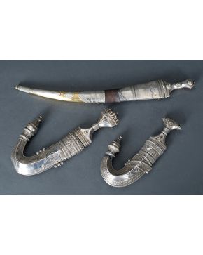 812-Lote formado por dos gumias yemeníes ff. s. XIX-pp. s. XX. con trabajada vaina y empuñadura en plata. y una daga con vaina en metal y plata.