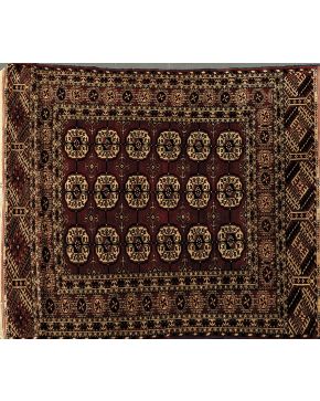 523-Alfombra persa en lana con tres hileras de hexágonos en el centro y cenefa de motivos geométricos. todo ello sobre campo marrón.